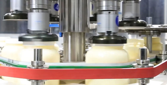 Enchimento do molho da salada da maionese e máquina tampando em volta de tampar do tampão